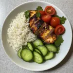 Spicy Salmon Bowls with Coconut Rice 5 inesboulila plate of rice and chicken and avocado and cucumber bc31e6b4 a474 4632 9eda 769629a0fa8e